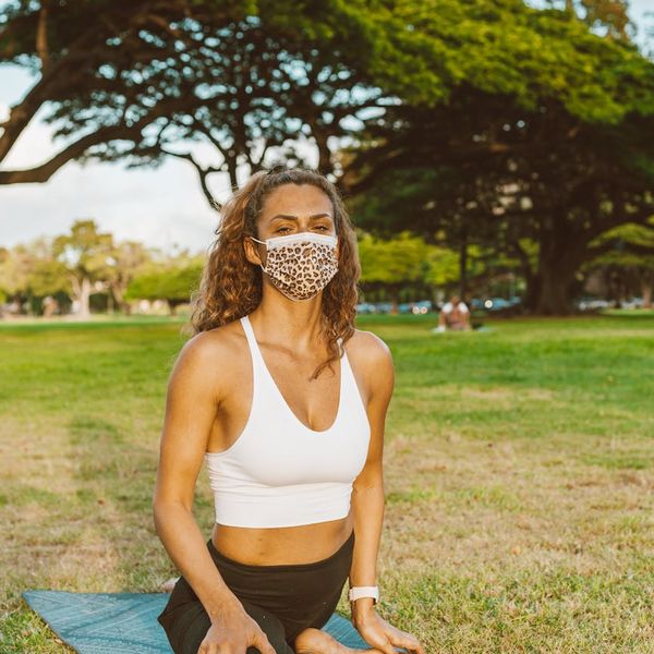 Person stretching outdoors, looking energized and serene against a natural backdrop.